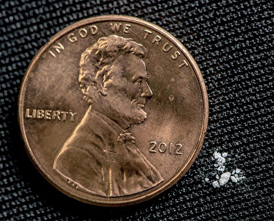 A tiny pinch of fentanyl powder next to a penny